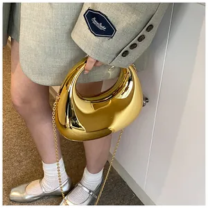 Sac croissant doré métallique avec bandoulière chaîne présenté dans un style de mode