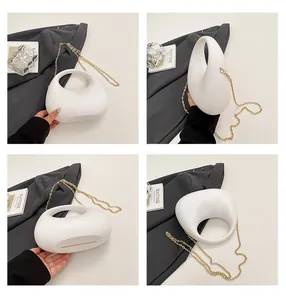 Detaillierte Mehrfachansicht der weißen Handtasche mit minimalistischem Hohlgriff und Goldkette