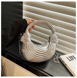 Detail of silver crescent bag with knotted handle and textured stripe finish