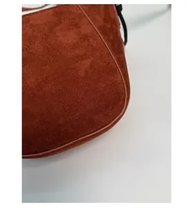 Detailierte Textur der braunen Wildledertasche mit präzisen Nähten und Finish