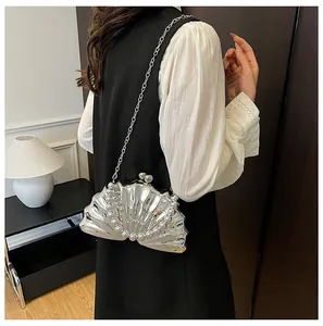 Detailed view of a silver shell evening bag with pearly beads and a sleek metal chain strap