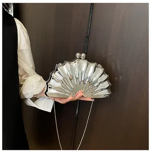 Detail of silver shell-shaped evening clutch with metallic radial texture and chain