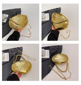 Détail du sac de soirée doré en forme de coquillage avec anse à perles et chaîne métal
