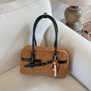 Detailed macro of brown suede Boston bag featuring vintage gold hardware and beaded tassels