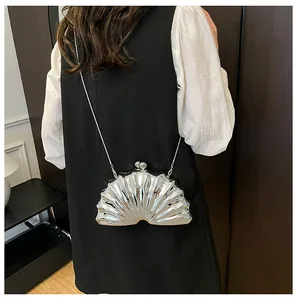 Close-up of a silver shell-shaped evening bag with a metallic finish and chain strap