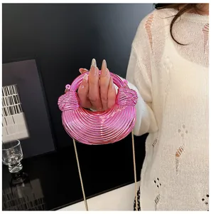 Nahaufnahme der metallisch-rosa Halbmondtasche mit Spiralstruktur und feiner Kette