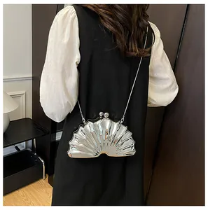 Silver metallic seashell clutch bag with radial ridges and sleek metal chain strap