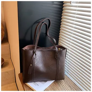 Detail of dark brown tote bag in faux leather with shoulder straps and zipper closure