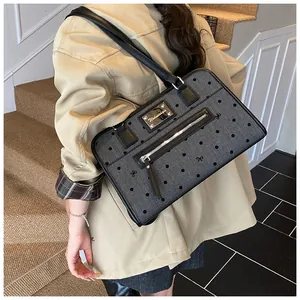 Détail du grand sac cabas gris à pois avec lanières en cuir noir et plaque métallique