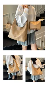 Detail of woven khaki shoulder bag and matching smooth clutch bag set with wide strap