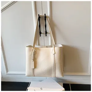 Detail of cream white tote bag with fine textured leather and vertical stitching