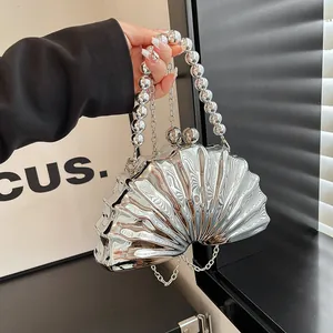 Silver shell-shaped evening clutch bag with metallic finish and beaded handle for weddings