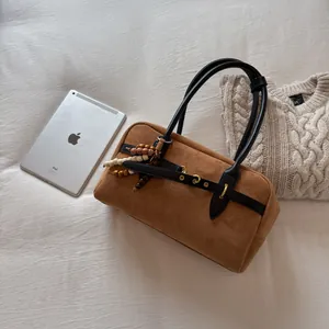 Detail of brown suede tote with black leather straps and colorful wooden bead charms