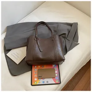 Deep brown large capacity faux leather tote bag showing spacious interior and sleek design