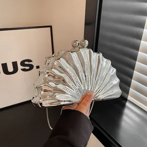 Silver shell-shaped evening clutch bag with metal mirror finish and chain strap