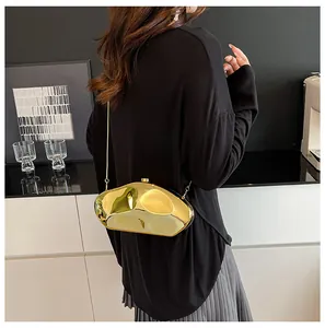 Elegante borsa a mano dorata con catena in metallo indossata da modella in interni moderni