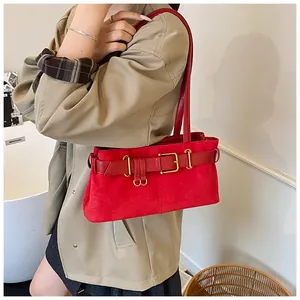 Vue détaillée du sac bandoulière en daim rouge avec boucle en cuir et fermoir doré
