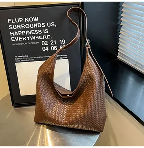 Detailed view of brown woven leather hobo bag with adjustable strap and metal buckle