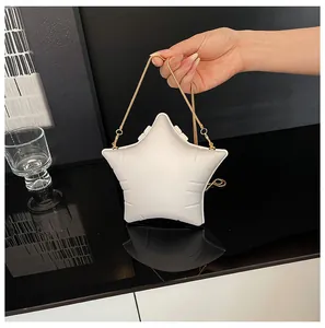 Detail shot of a white star-shaped bag with a gold chain strap and padded design