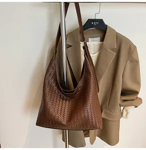Detailed view of dark brown woven leather tote bag with adjustable shoulder strap