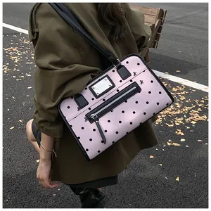Détail du sac à bandoulière rose à pois avec broderie nœud et fermeture éclair en métal