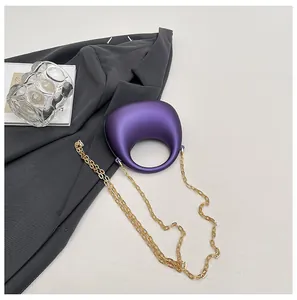 Macro-opname van paarse matte handtas in kiezelvorm met grote gouden ketting