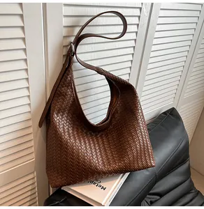 Macro detail of brown woven leather Hobo bag featuring premium Intrecciato craftsmanship