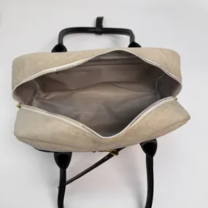 Top view showing spacious beige suede interior with gray lining and inner zipper pocket
