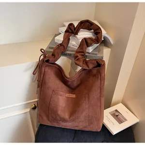 Detailed view of dark brown corduroy tote bag with pleated cloud shoulder strap and patch pocket