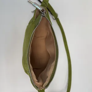 Detailansicht der grünen Ledertasche innen mit Stofffutter und silbernem Reißverschluss