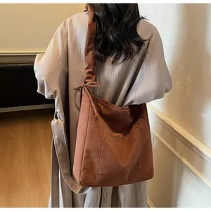 Detail of caramel suede tote bag featuring a pleated drawstring shoulder strap design