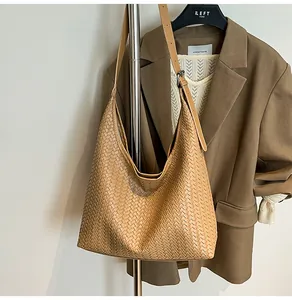 Detailed close-up of caramel leather woven hobo bag with an adjustable wide strap