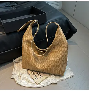 Macro shot of brown woven leather texture and metal buckle on large tote shoulder bag