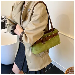 Détail du sac à bandoulière en daim vert avec boucle de ceinture décorative en cuir marron