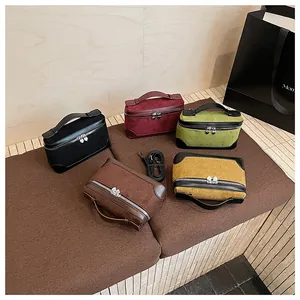 Détail de sacs à main en daim multicolores avec fermeture éclair cœur et bandoulière amovible