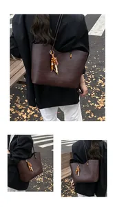 Detail of dark brown woven tote bag featuring ethnic wood bead tassels and 秋 texture