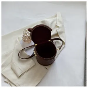 Top view of mini cylindrical bucket bag showing brown lining and golden hardware