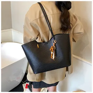 Detail of black woven tote bag featuring diamond texture and colorful wooden bead charms