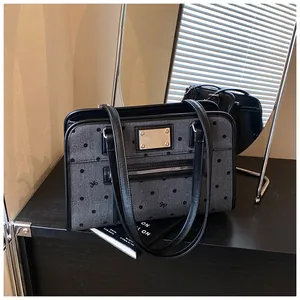 Détail du sac fourre-tout en denim avec pois noirs, nœuds et plaque de logo en métal