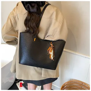 Detail of black woven tote bag featuring beaded tassel and durable double shoulder straps