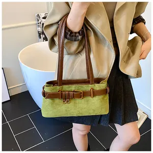 Gros plan du sac cabas en daim vert avec lanières en cuir marron et boucle dorée vintage
