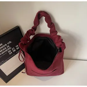 Detailed close-up of wine red matte bag featuring a unique ruched cloud strap and metal zipper