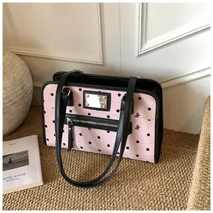 Détail du sac à main rose à pois avec poche zippée argentée et nœuds noirs élégants