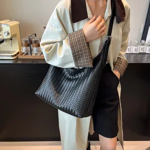 Close-up of the handcrafted black woven hobo bag with detailed leather texture design