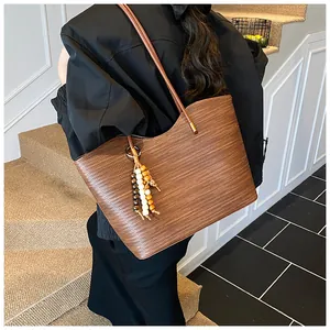 Detailed texture of brown woven leather tote bag with elegant beaded tassel accessory