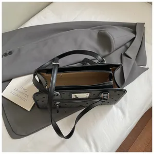 Vue détaillée du sac cabas noir avec compartiment intérieur et poche zippée devant