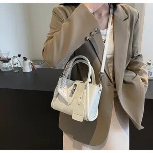 Cream bucket bag with textured leather, metal lock and decorative geometric silk scarf