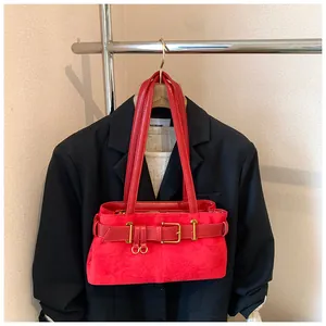 Détail du sac fourre-tout rouge en daim avec boucle dorée et doubles poignées