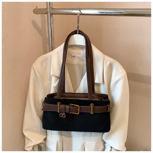 Détail du sac cabas en daim noir avec anses en cuir marron et boucle métallique