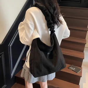 Retro black matte tote bag with ruffled shoulder strap shown on a model in minimalist style